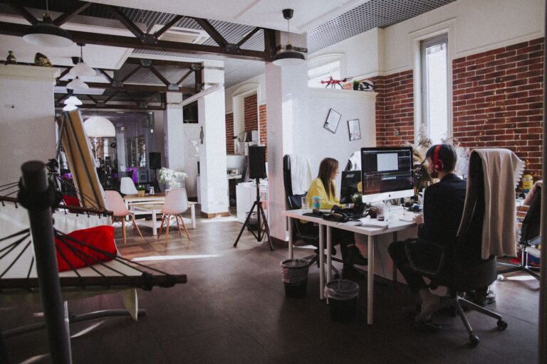 Fitness business owner reviewing an email marketing campaign on a laptop in a modern workspace